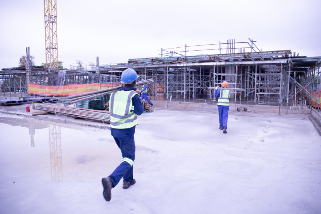 Tri star construction workers carrying scaffolding on a roof top at a cnstruction site